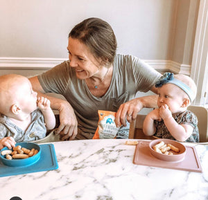 mom with twin babies eating Puffworks baby puffs