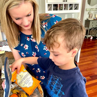 mom helping son pack school lunch